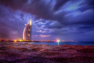 a tall building sitting on top of a beach next to the ocean